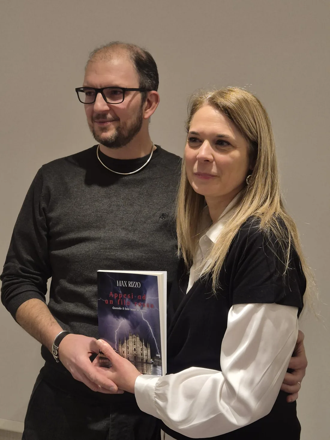 Max Rizzo insieme a una lettrice che mostra una copia del romanzo